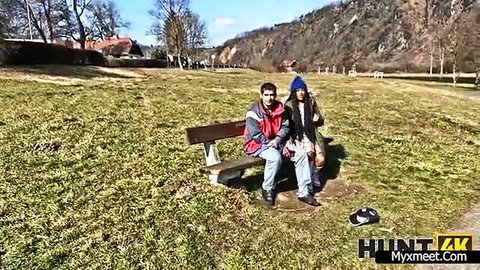 Amateur couple on park bench, guy with girl in hijab outdoors