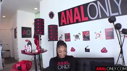 Cali Caliente smiling in anal only room, black top, braids