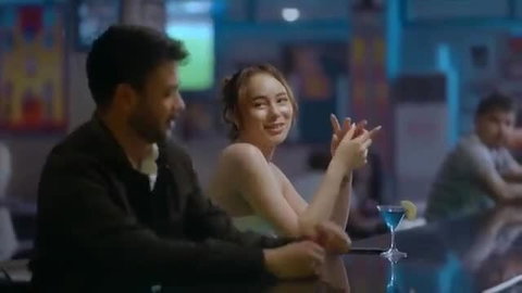 Julia Victoria smiling seductively at bar in tight dress nude scene