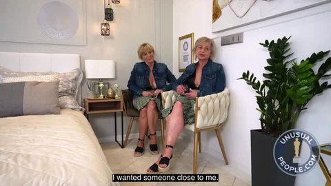 Mature blonde friends in denim skirts on bed, close friendship vibes
