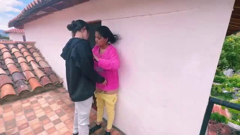 Ex-girlfriend in pink hoodie and yellow pants pinned against wall by hooded guy