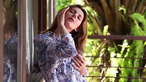 Oliana in Eminse Oliana touches face seductively by window