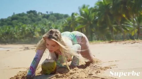 Blonde Abbegaile Moore in skimpy swimsuit digs coconut on beach