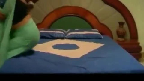 Curvy Latina woman in green dress straddles on bed in vintage sex scene