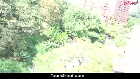 Young Colombian beauty surrounded by lush greenery in steamy outdoor scene