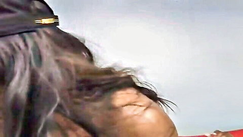 Ebony woman in cap squints eyes in ecstasy with mouth open during intense blowjob