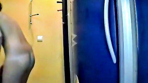 Nude woman bending over in kitchen, showing curvy ass