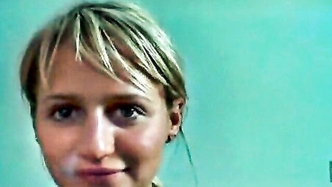 Blonde woman with natural titties smiling in close-up portrait