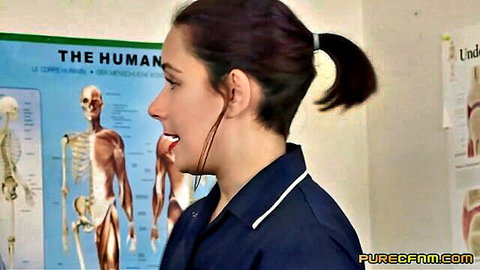 Sexy nurse in tight uniform smiles with headset in medical room with anatomy posters