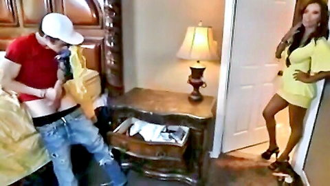 Young guy pulls down pants exposing hard cock while seductive tanned brunette MILF in yellow mini dress watches