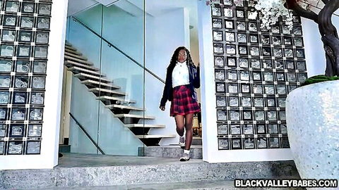 Sexy ebony schoolgirl in short plaid skirt white blouse strutting teasingly in luxury hallway