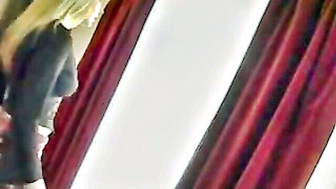 Blonde MILF in revealing black top by red curtains