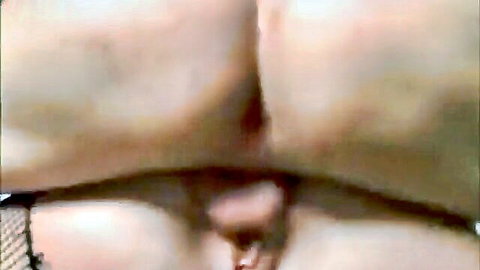 Close-up of thick mature woman's wet pussy lips exposed through black fishnet stockings