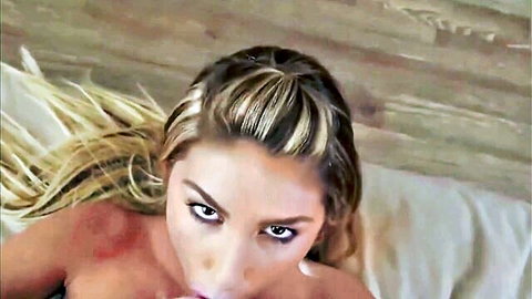Topless blonde with perky tits and intense gaze lying seductively on bed