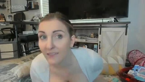 Kelly Payne busty MILF in white top smiling on cam
