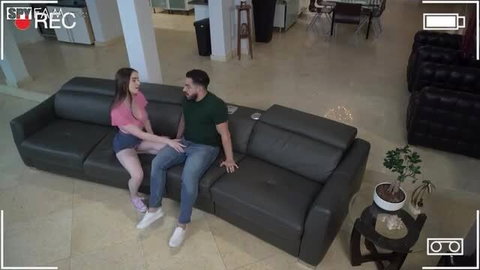 Hazel Moore in pink top shorts sits close with stepbro on couch