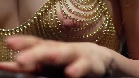 Spicy vixen in gold chain bikini top showing perky nipple