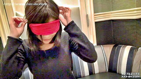 Asian woman with short black hair putting on red blindfold, teasing solo