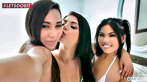 Three sexy brunette babes in skimpy bikinis kissing and smiling in bathroom mirror selfie