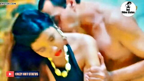 Shirtless muscular man passionately embraces and kisses blue-haired woman's neck in steamy poolside hug