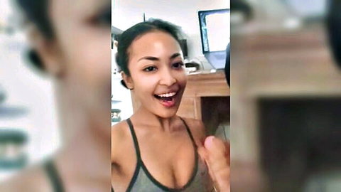 Smiling brunette Latina in low-cut tank top showing cleavage