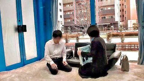 Asian couple in modest attire reading book intimately on floor