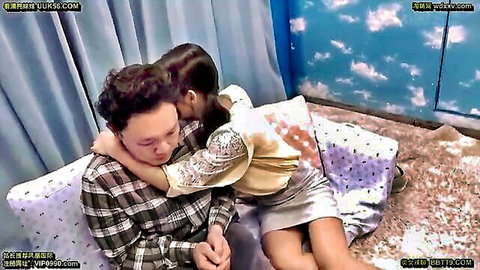 Asian woman in short skirt sits on man's lap in intimate bedroom embrace