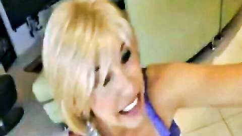 Smiling blonde MILF in purple top showing cleavage, POV adult thumbnail