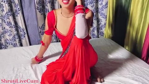 Desi Indian babe in red saree smiles seductively on bed