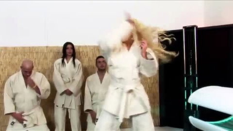 Blonde bombshell in gi grabs hair amid martial arts group