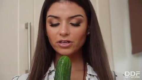 Busty brunette bombshell sucking huge cucumber closeup