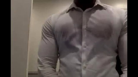 Muscular black man flexing huge biceps in wet white shirt