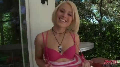 Blonde babe in pink lingerie smiling outdoors, ready for dick sucking