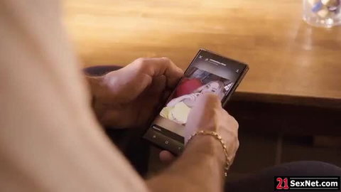 Melani Tucker on phone viewing sexy pics at table