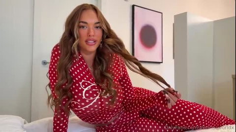 Alanna Pow in red polka dot lingerie on bed, teasing cum covered tits