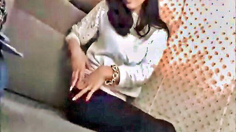 Japanese babe spreads fingers teasing pussy over tight black pants on couch