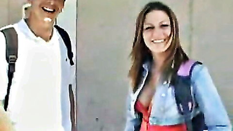 Busty college girl flashes deep cleavage smiling at backpack guy student outdoors