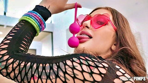Bella Blu teases with pink Ben Wa balls, tongue out in fishnet top and sunglasses