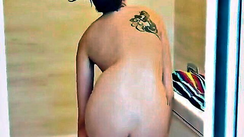 Nude brunette Megan Sage bending over, showing back tattoo and ass