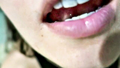 Seductive blonde woman with open mouth and tongue in ASMR hot pants close-up