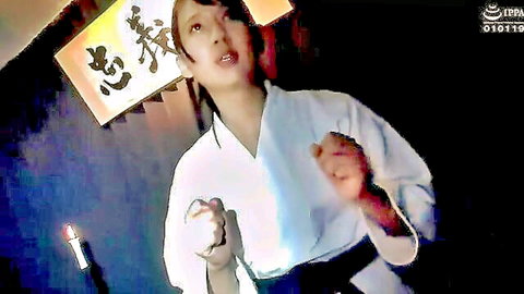 Japanese woman in white karate gi smiling seductively