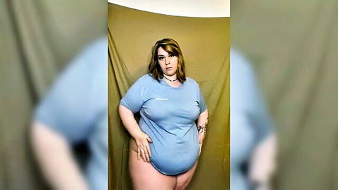 Cute curvy blonde in oversized blue t-shirt posing confidently