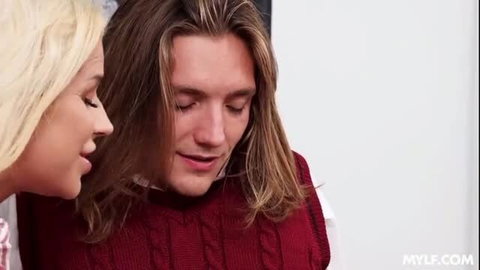 Blonde stepmom whispers to long-haired stepson in red sweater