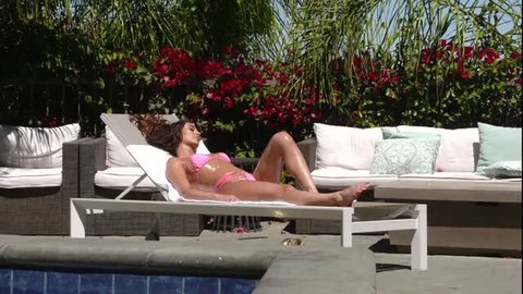 Christiana Cinn in pink bikini sunbathing by pool, sexy soles up