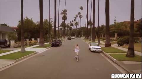 Kendra Sunderland rides bike in sexy dress on sunny street
