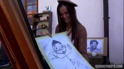 Smiling Czech brunette amateur holds funny sketch in casual hat and cardigan