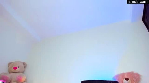 Cozy bedroom with teddy bears on walls, purple neon lighting