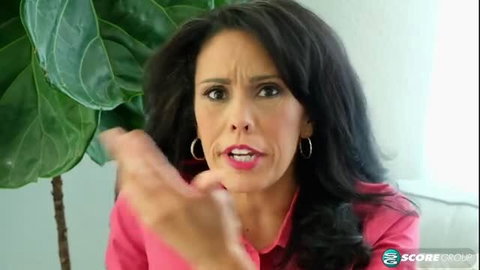 Gypsy Vixen in pink top, expressive face, big hoops, dark wavy hair