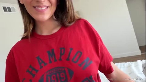 Aubry Babcock smiling in oversized red Champion tee, teasing cleavage