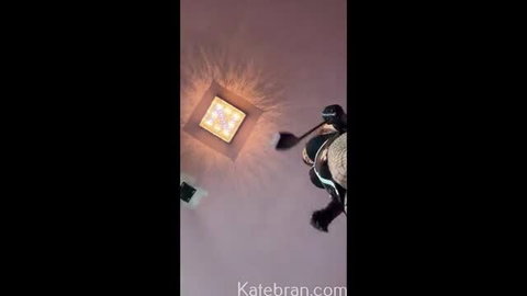 Kate in shiny latex femdom outfit crawling on ceiling, dominant tease